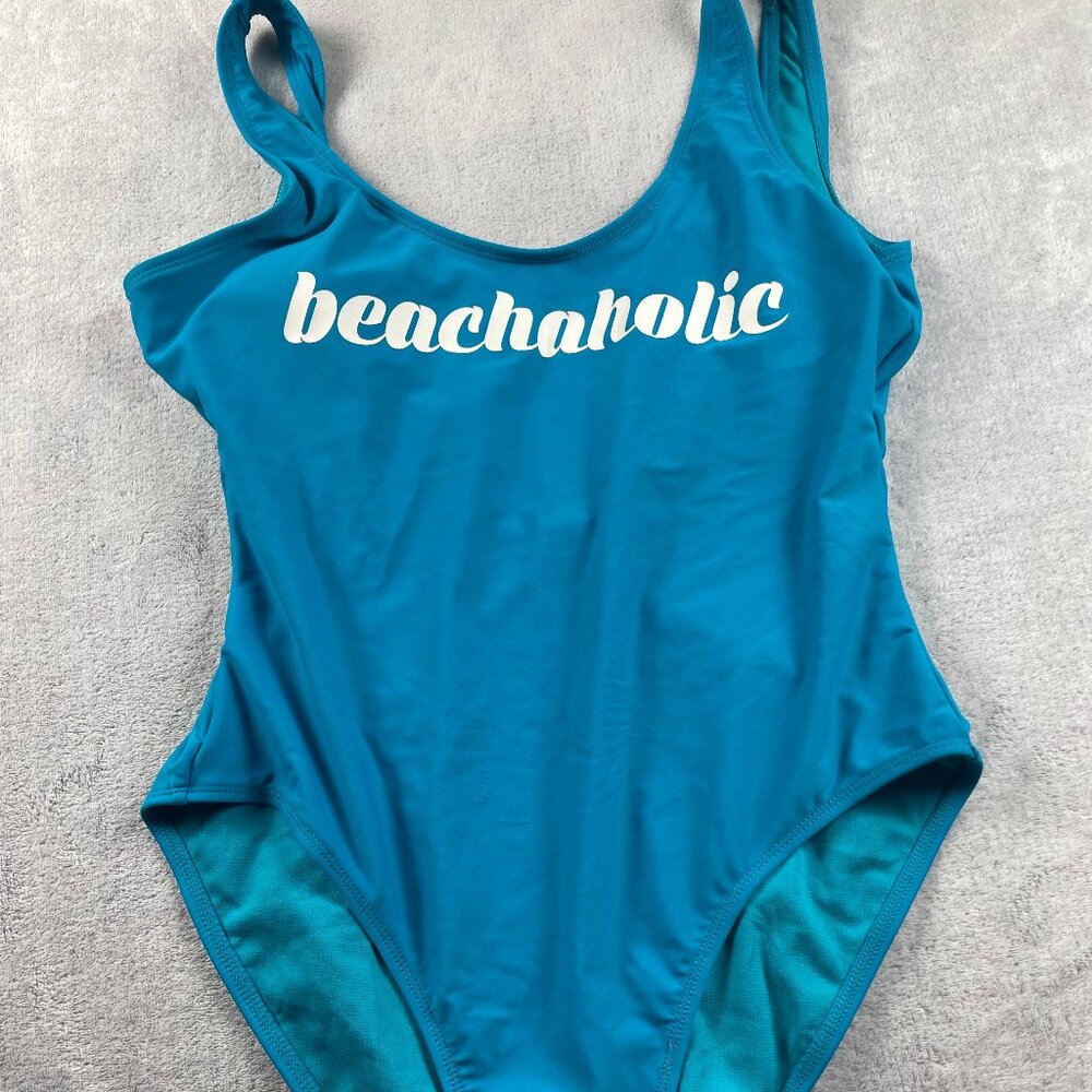 A stylish blue one‑piece swimsuit featuring the bold vertical “beachaholic”